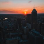 A stunning aerial view of Indianapolis downtown skyline during sunset, capturing the vibrant cityscape.