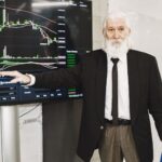 Senior businessman presenting stock market analysis with a chart display in a corporate setting.