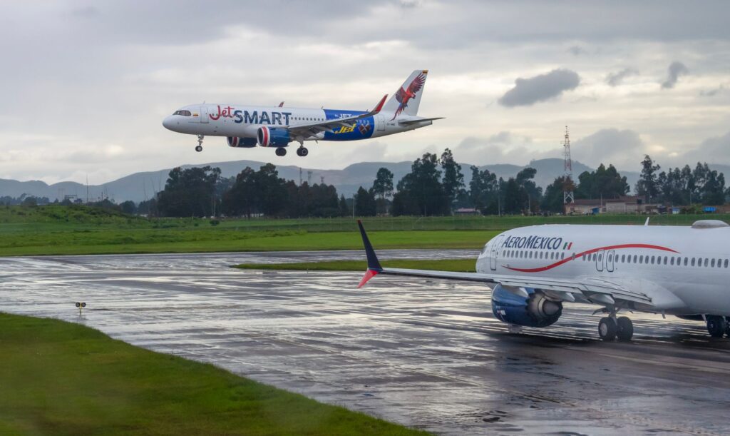 JetSmart and AeroMexico aircraft on runway under cloudy sky, showcasing aviation travel.