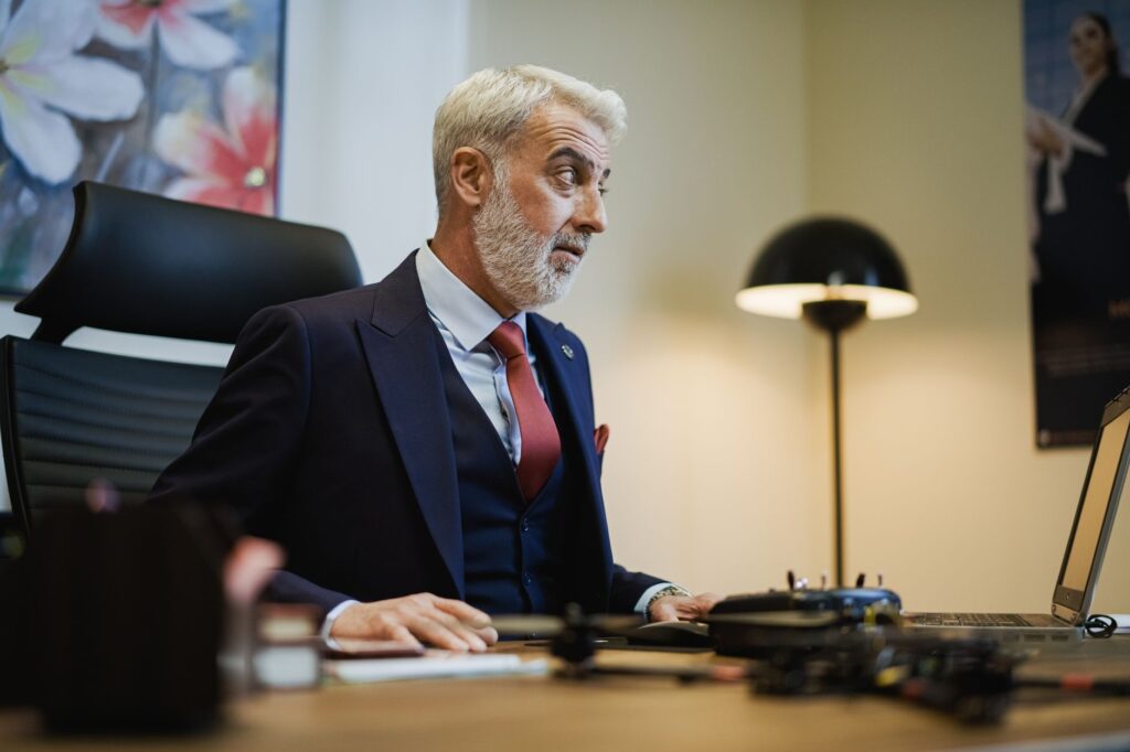 Senior businessman at his office desk, focused on work, with a stylish modern setup.