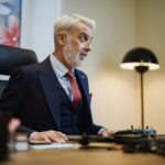Senior businessman at his office desk, focused on work, with a stylish modern setup.
