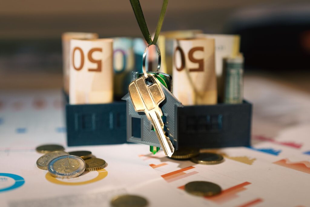 Keys hanging with money and charts, symbolizing real estate investment and financial planning.
