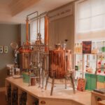 A beautifully lit distillery room showcasing elegant copper brewing equipment.