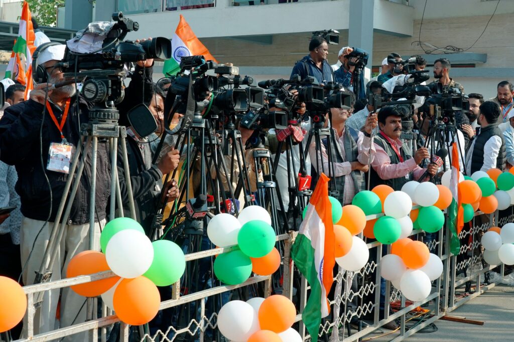 Journalists and videographers gather with cameras in Ahmedabad, capturing a vibrant scene.