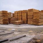 Piles of wooden planks prepared for distribution in an outdoor industrial site.