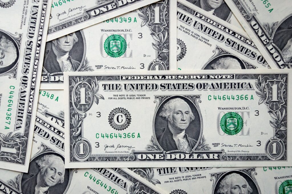 Detailed close-up of multiple one dollar bills showcasing U.S. currency design.