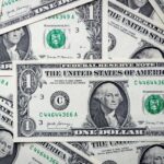 Detailed close-up of multiple one dollar bills showcasing U.S. currency design.