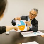Professional setting with colleagues discussing charts during a business meeting.