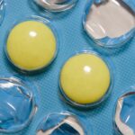Close-up of yellow tablets in a blue blister pack, highlighting pharmaceutical and healthcare themes.