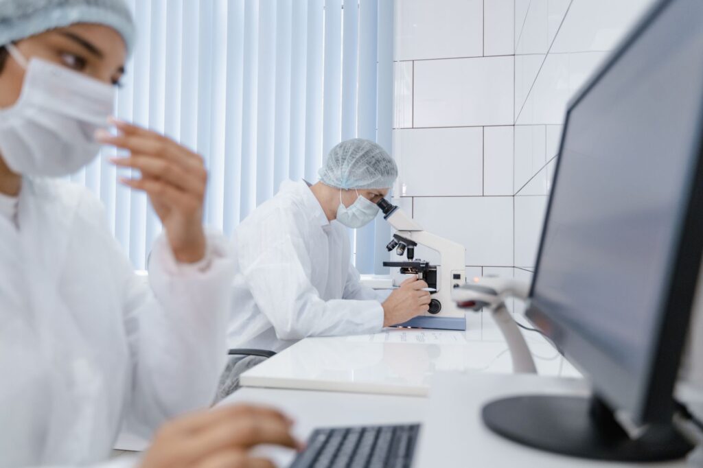 Researchers wearing PPE work diligently in a laboratory using advanced equipment.