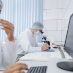 Researchers wearing PPE work diligently in a laboratory using advanced equipment.