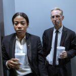 Serious detectives in suits holding cups, suggesting a tense investigation setting.