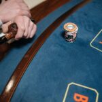 Detailed view of a casino gaming table with poker chips and a wooden pipe on the side.