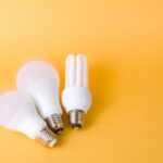 Bright and efficient LED and CFL bulbs on vibrant yellow backdrop.