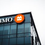 Close-up of a modern building corner featuring a BMO logo on its glass facade.