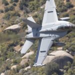 F-18 Super Hornet flies low over Kernville, California, showcasing speed and agility amidst rugged terrain.