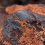 Detailed texture of iron ore rock in Minas Gerais, Brazil, showcasing earthy tones and mineral structures.