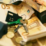 Euro currency with house keys and miniature models, symbolizing real estate investment.