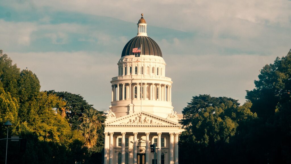 Captivating view of the California State Capitol amidst lush greenery under a clear sky.
