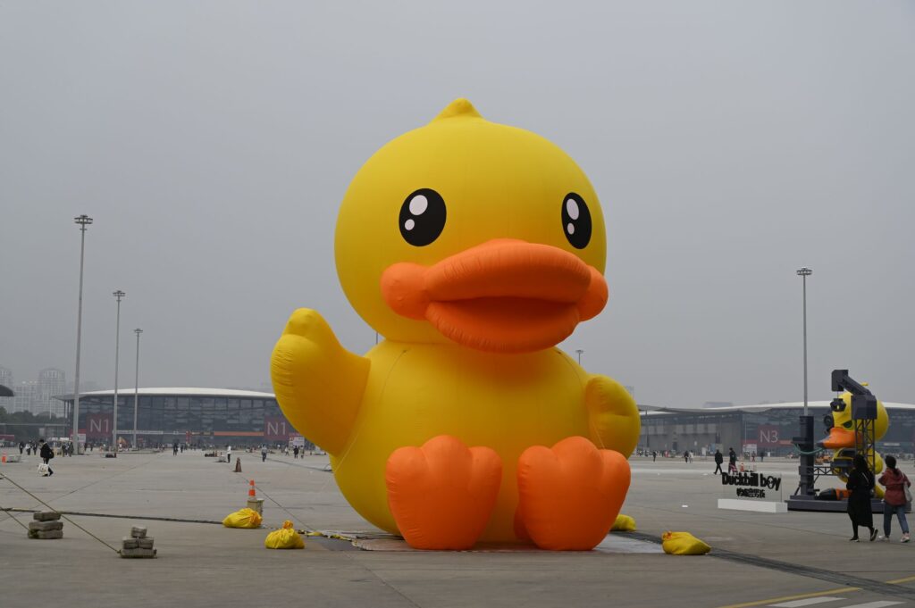 Large yellow inflatable duck at an outdoor event showcasing fun and creativity.