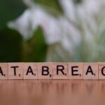Close-up of Scrabble tiles spelling 'data breach' on a blurred background