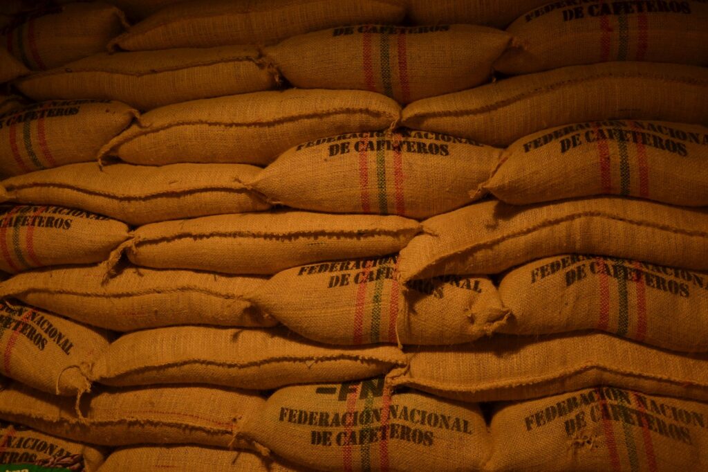 Rows of coffee bean sacks from Federación Nacional de Cafeteros in a Colombian warehouse