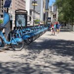 A bustling bike share station in downtown Chicago on a sunny day.
