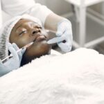 A woman receiving a cosmetic injection with syringe in a medical setting.