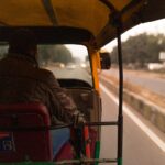 Inside view of a moving autorickshaw on Gurugram road, capturing urban dynamics.