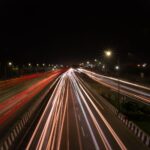 Long exposure shot capturing dynamic city traffic on Delhi highway at night.