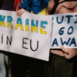 Protest with signs supporting Ukraine in EU and opposing Putin. Capturing a social movement outdoors.
