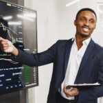 Businessman presents financial data using graphs, showcasing technology and analysis in a corporate environment.