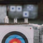 Close-up of archery targets and steel cans used for target practice at an outdoor range.