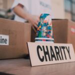 Close-up of charity boxes labeled for donation, featuring medicine and colorful paper cups.