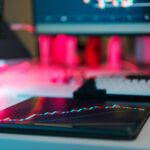 High-tech trading setup with charts on tablet and computer screens, representing data analysis and financial trends.