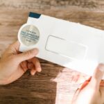 Hands holding a pre-approved offer envelope on a wooden table. Perfect for financial marketing.