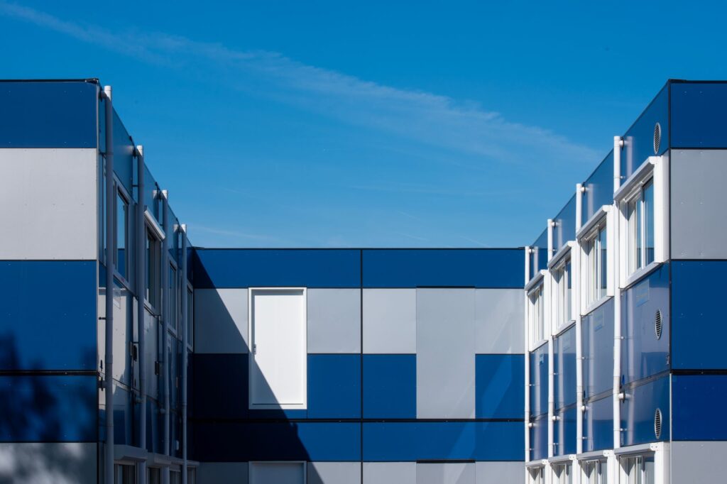 Distinctive modular building with blue panels under a clear sky, showcasing geometric design