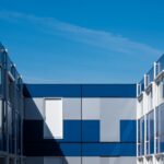 Distinctive modular building with blue panels under a clear sky, showcasing geometric design