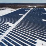 A drone-captured image of a large solar farm in Kingston, Canada, surrounded by snow.