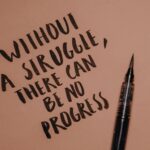 Handwritten motivational quote using a brush pen on a textured background for inspiration.