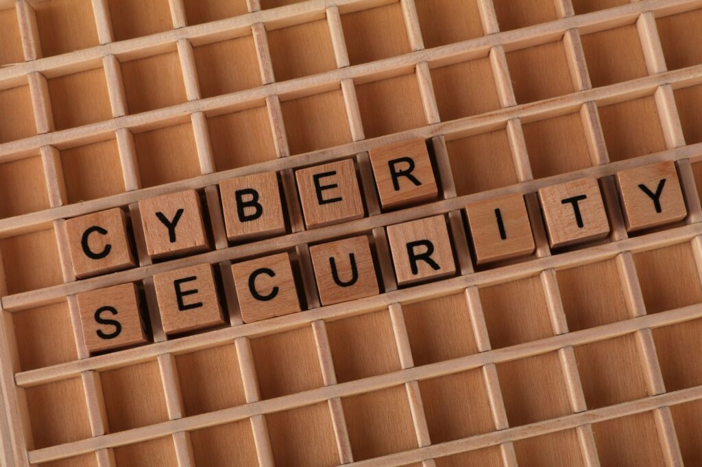 Wooden blocks spelling 'Cyber Security' on a wooden grid background.
