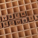 Wooden blocks spelling 'Cyber Security' on a wooden grid background.