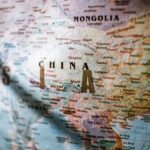 Paper political world map with Asian countries borders and coastline near water