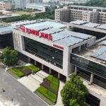 Aerial view of a modern building with solar panels, showcasing sustainable architecture.