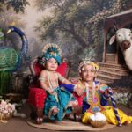 Children dressed as Krishna for Janmashtami celebration with cow and peacock decor.