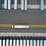Top-down aerial image of truck trailers parked in a lot with distinct yellow markings.