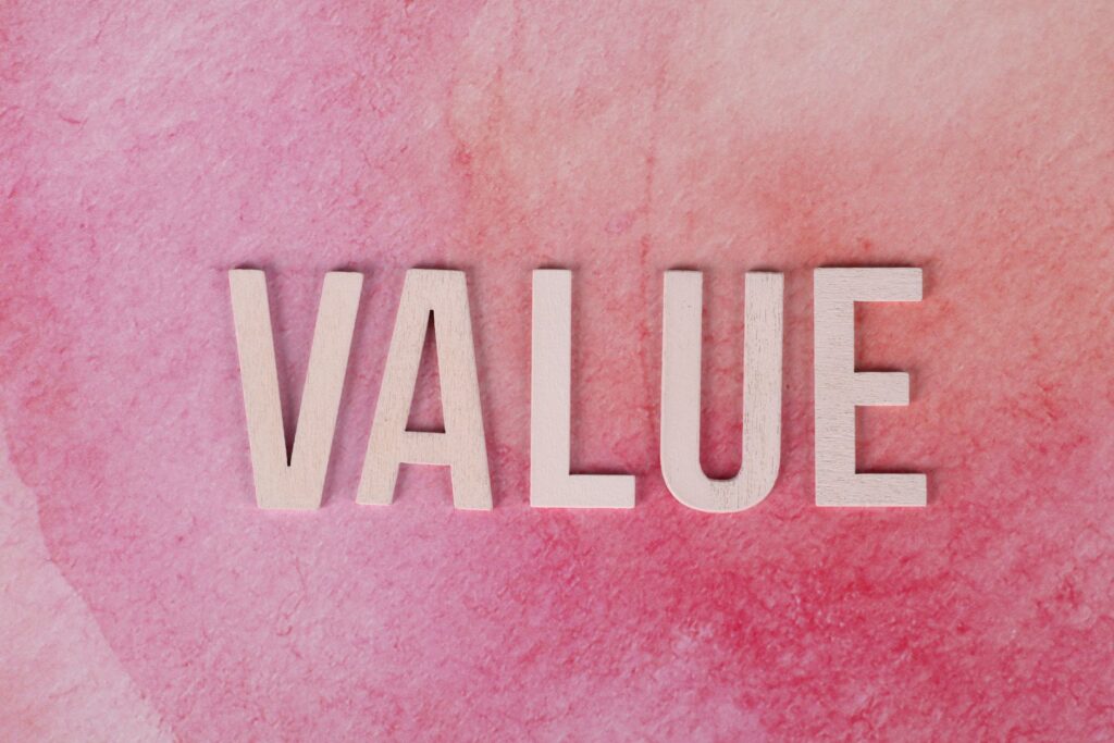 The word 'VALUE' in bold letters on a textured pink background.