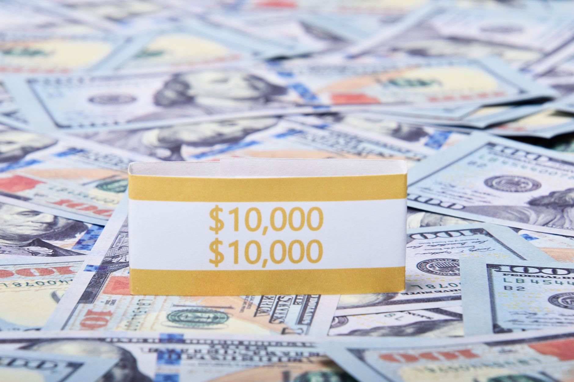 Close-up of US dollar banknotes with a $10,000 money band, ideal for finance and investment themes.