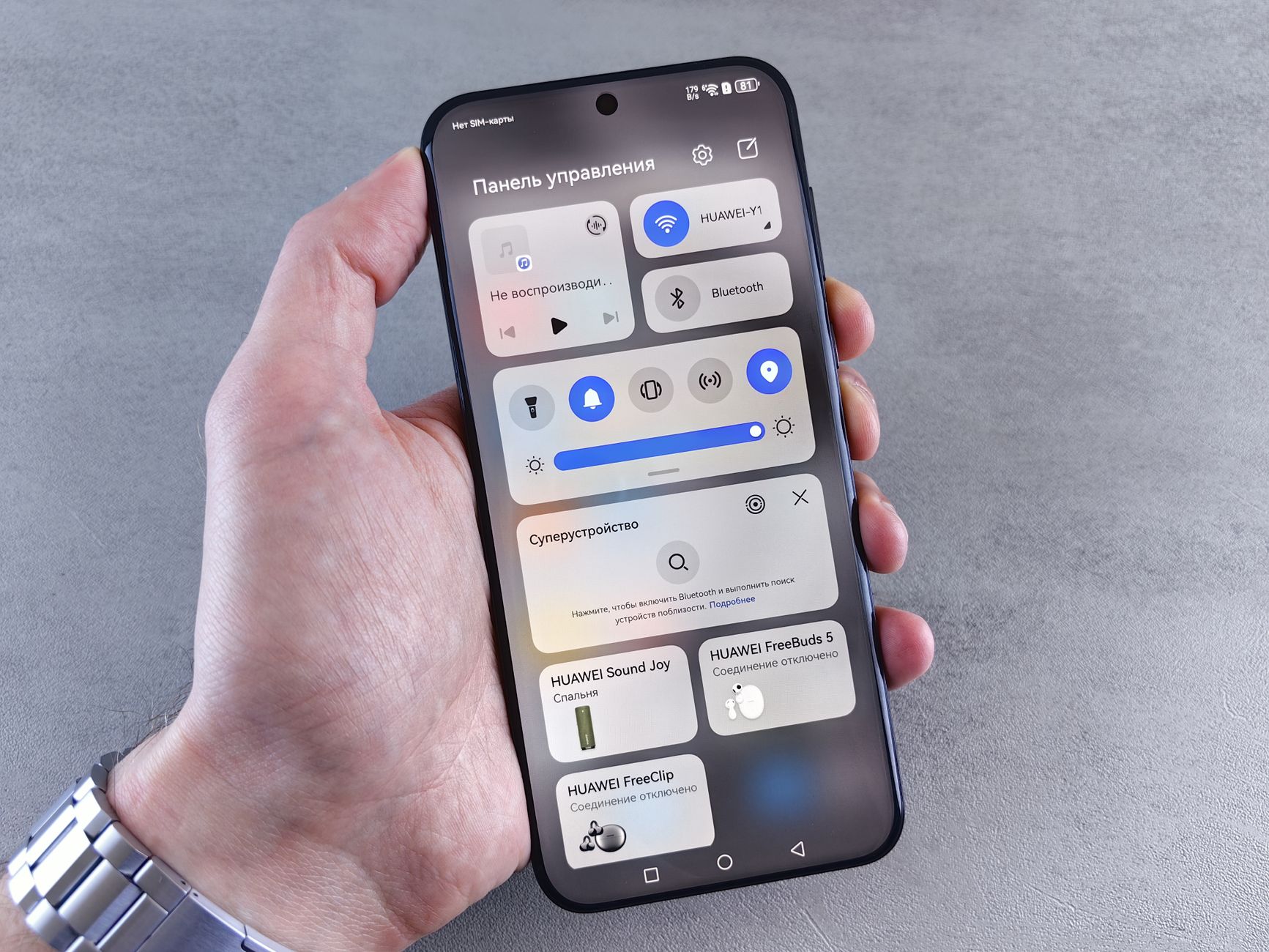 Close-up of a hand holding a smartphone showing a control panel interface.