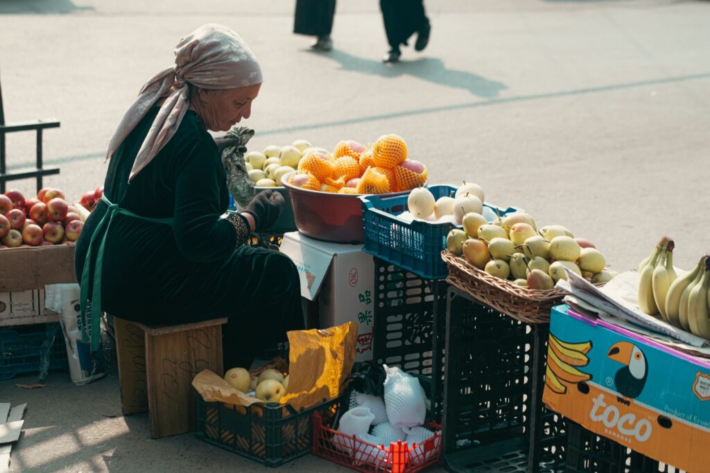 A local vendor selling fresh fruits at an Uzbek street market, showcasing daily life in Uzbekistan.